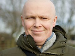 Man without hair smiling at camera