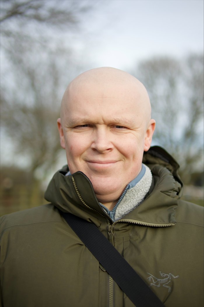 Man without hair smiling at camera