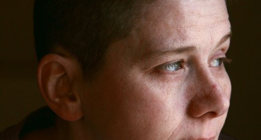 A person, alone, looking away with a thoughtful expression