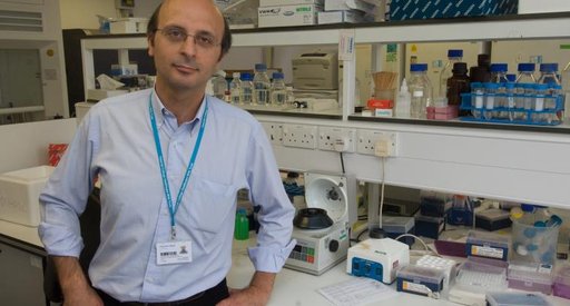 A male scientist - Professor Karadimitris - poses for a photograph in his lab
