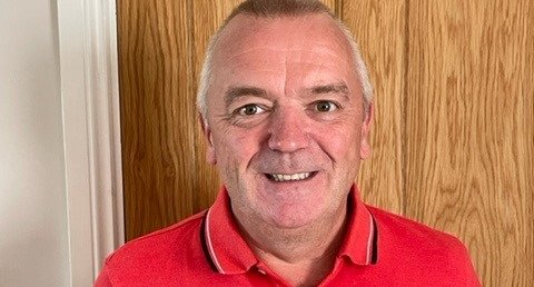 Craig, wearing a red t-shirt and smiling
