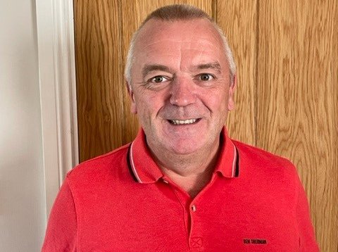 Craig, wearing a red t-shirt and smiling