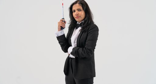 A scientist poses with a medical instrument against a white background.