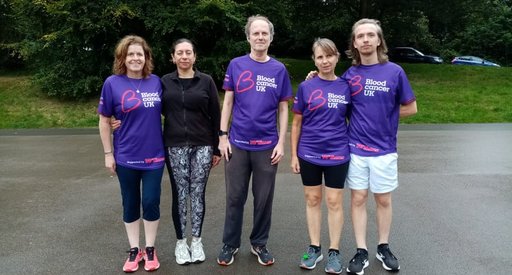 A group of five people pose together on a path outside; they wear purple Blood Cancer UK T shirts.