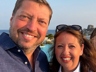 Matthew Wilson and his partner smile on a sunny day