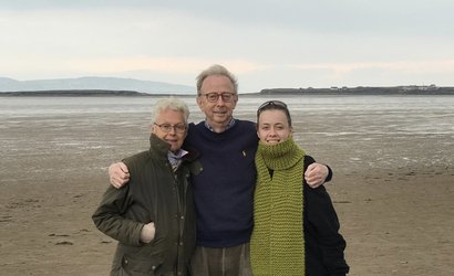 A group shot of Jasmine and her mum and dad on a windswept beach near the Wirral
