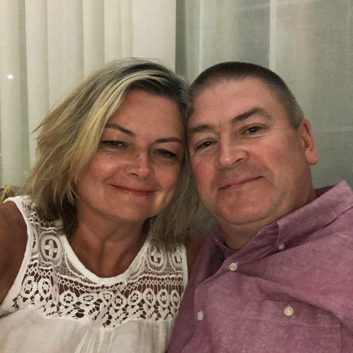 A middle aged couple pose for a photo together indoors