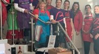 The Grimsby Branch celebrate running for 60 years - twelve of them stand smiling at the camera, many of them wearing red and purple Blood Cancer UK t-shirts