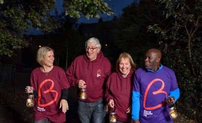 A group of supporters smile and wear their Blood Cancer UK t-shirts as they take part in Walk of Light