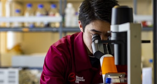 Researcher looking through a microscope