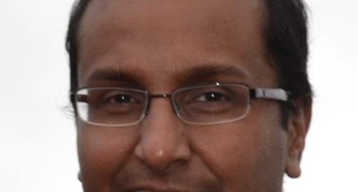 A man wearing glasses in a headshot.