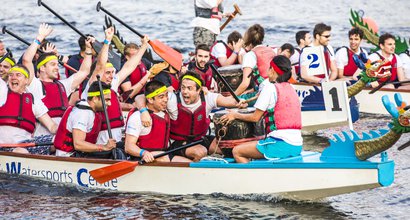 A boat race team celebrating after the race, on their boat.