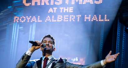 A singer finishes a song, arms outstretched, onstage at Christmas with the Stars at the Royal Albert Hall
