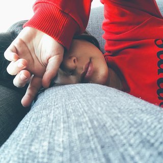 Woman lying on sofa looking tired.