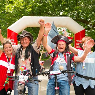 Bloodwise fundraisers in fancy dress as pirates, cheering at the finish line of a marathon