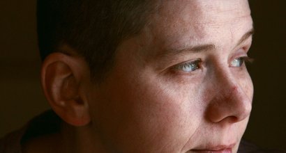 A person, alone, looking away with a thoughtful expression