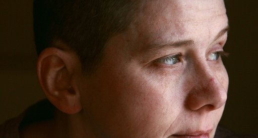 A person, alone, looking away with a thoughtful expression